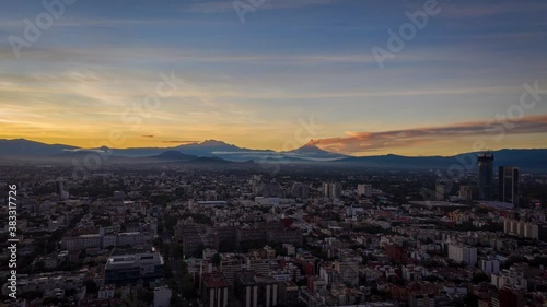 Epic hyperlapse sunrise with 2 volcanoes as foreground, one which is active with smoke. photo