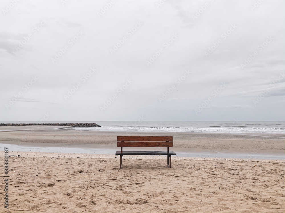 Wooden fence on sand beach with cloudy sky Wooden fence on sand beach with cloudy sky