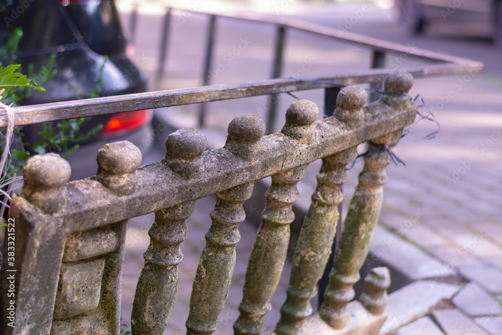 An old stone balustrade in need of repair and restoration. Dilapidated fence. Close-up, selective focus
