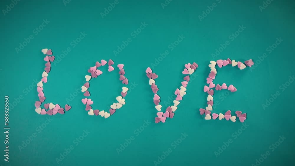 Stop motion animation with heart shaped candy creating the word LOVE. Stop motion animation with heart shaped candy creating the word LOVE.
