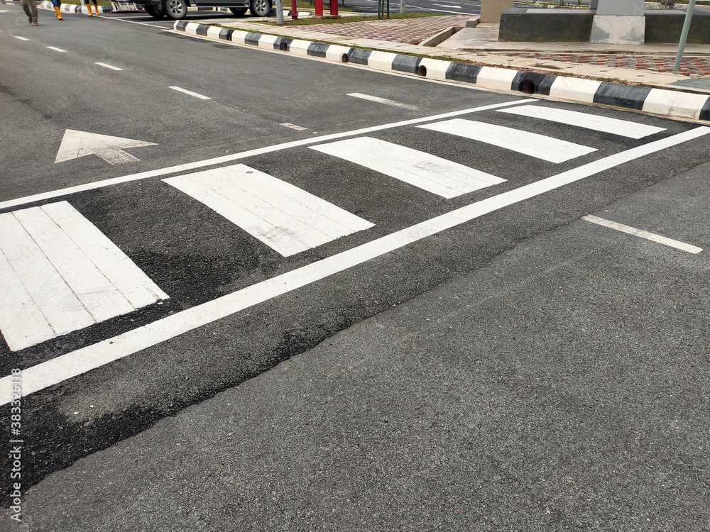 Zebra crossing for pedestrians on the road. Made of thermoplastic material and has light-reflective particles. Provides safety advantages to pedestrians.