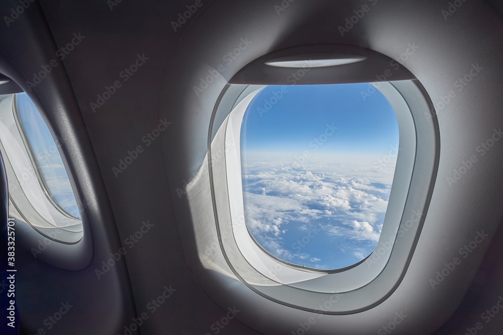Naklejka premium In flight view above the clouds and ocean, air travel