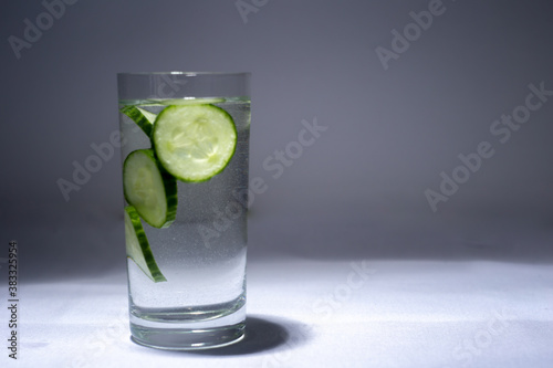 Glass cup with water and cucumber slices