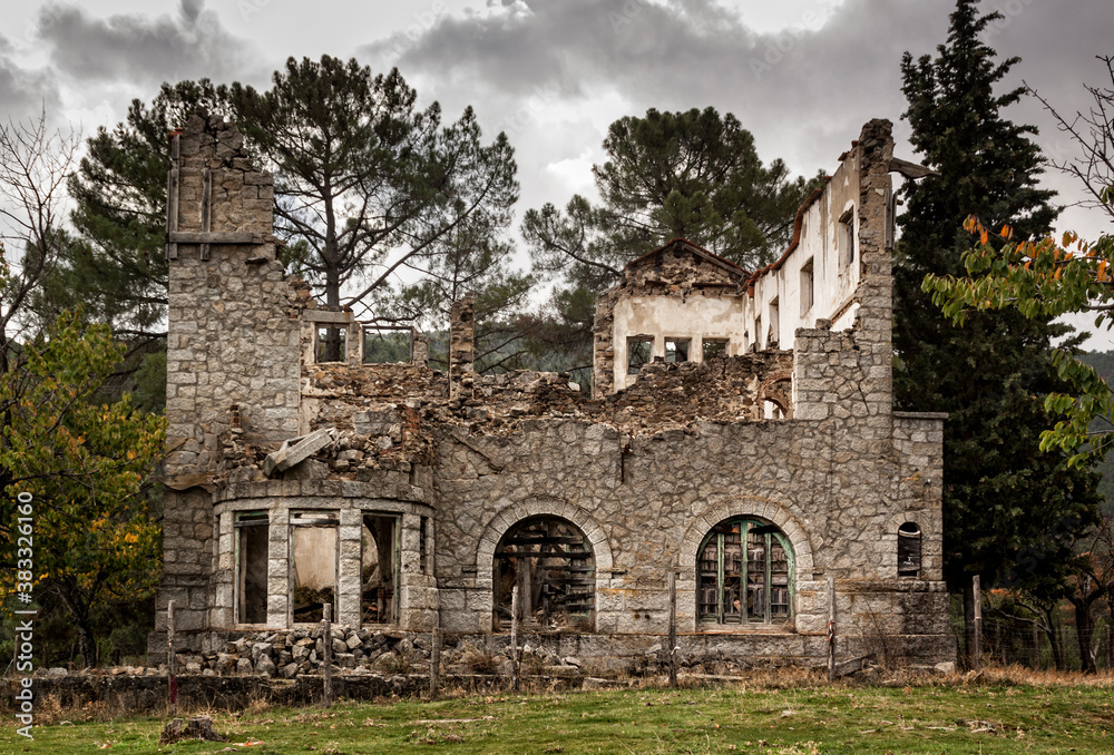 Abandoned house, stone wall with collapsed windows, in the chestnut grove of El Tiemblo, Avila. Castile and Leon, Spain