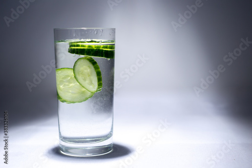 Glass cup with water and cucumber slices
