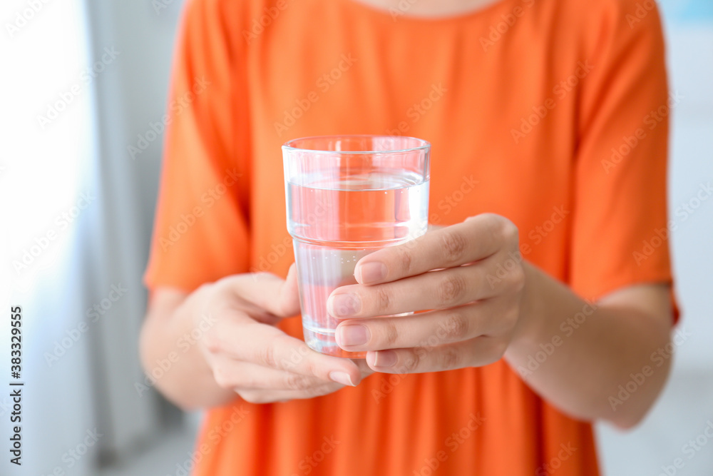 Woman holding glass of water at home, closeup Woman holding glass of water at home, closeup