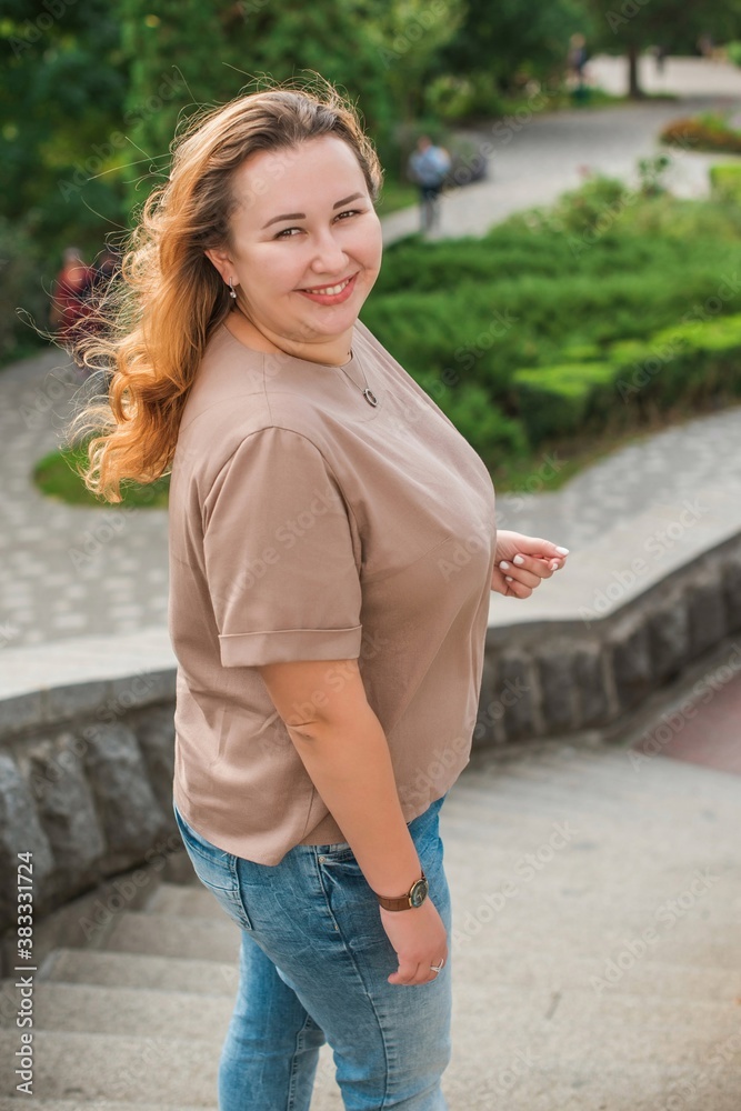 Fototapeta premium Happy smiling beautiful plus size model . Portrait large girl smiling on a sunny day with good mood, Photo of new age standard of beauty