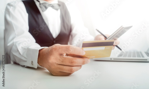 Business people use tablets and hold credit cards as an online shopping concept With a calculator and a book placed on the table