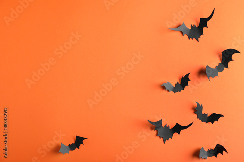 Paper bats on orange background  flat lay with space for text. Halloween decor
