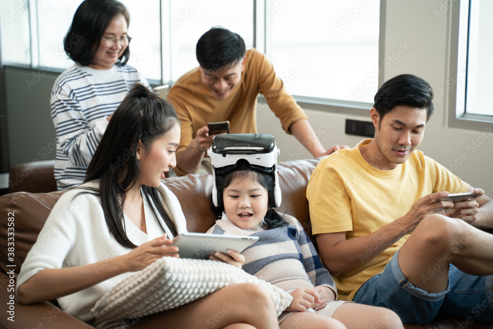 5G Technology for Families concept.Everyone sitting in sofa and using digital devices in living room.Big family grandmother grandfather and kids spending time together at home. 5G Technology for Families concept.Everyone sitting in sofa and using digital devices in living room.Big family grandmother grandfather and kids spending time together at home.