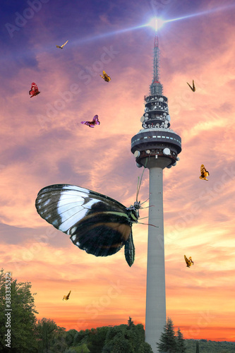 Surreal photography of Torre España (el Pirulí) at sunset invaded by giant butterflies