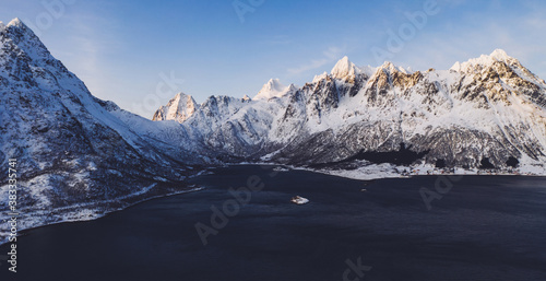 Breathtaking bird's eye view of majestic fjord mountains covered with snow in winter. Aerial view of scenery rock peaks, picturesque beautiful nature landscape. Lofoten Island surrounds by Nordic sea © BullRun