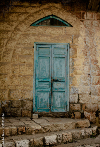 old blue wooden door in the arched stone wall photo