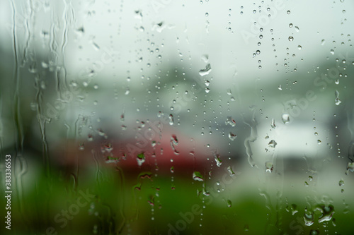 blurred rain drops on outside window glass