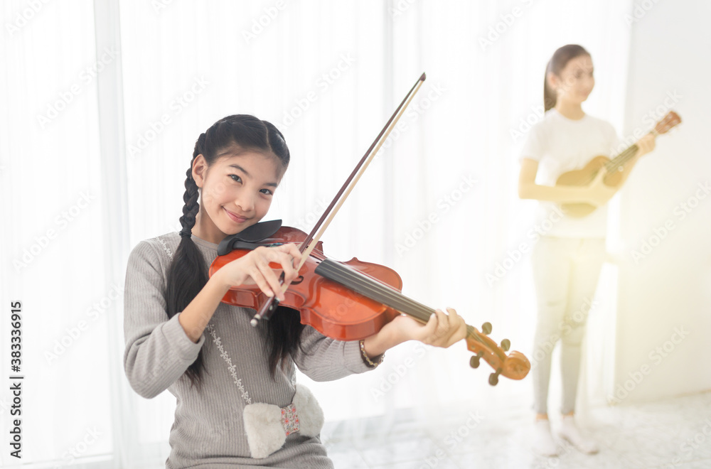 close up asian children holding violin on her shoulder, she play violin in classroom, she show violin skill and present melody with her friend, couple asian children in musical training time close up asian children holding violin on her shoulder, she play violin in classroom, she show violin skill and present melody with her friend, couple asian children in musical training time