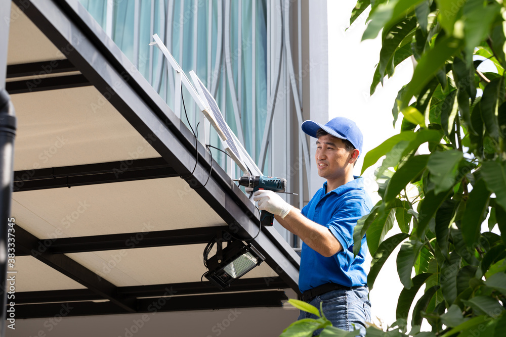 Asian workers technicians man installing solar photovoltaic panels for LED lamps on the roof of the house. Exterior solar cell system installation concept