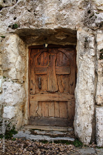old wooden chapel door in stone wall photo
