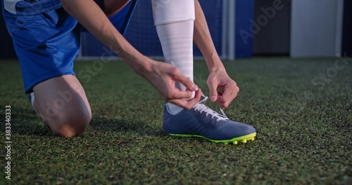 Football player tying his shoe lace preparing for the game