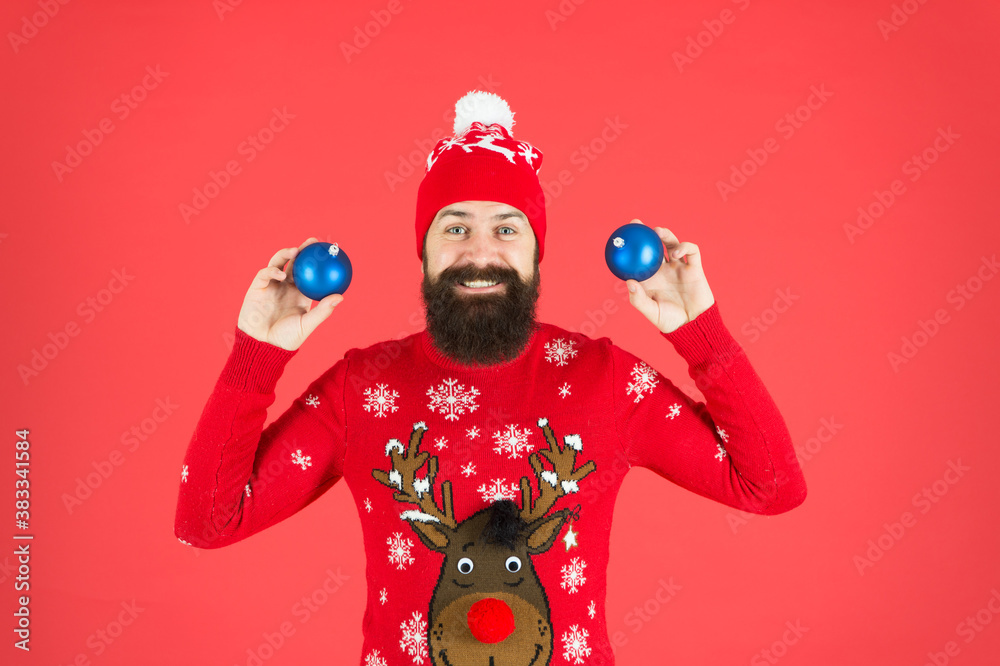 New year concept. Hipster smiling cheerful bearded man wear winter sweater and hat hold balls. Christmas party. Winter holidays. Winter decorations. How to handle top holiday stress triggers