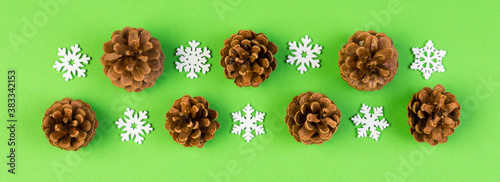 Top view Banner of holiday composition made of pine cones and white snowflakes on colorful background. Winter time and Christmas concept with copy space