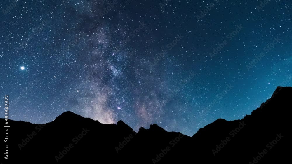 Milky way panorama above the mountains. Time lapse video of the night starry sky with the milky way, stars, planets and constellations in motion. Immensity of the deep universe.