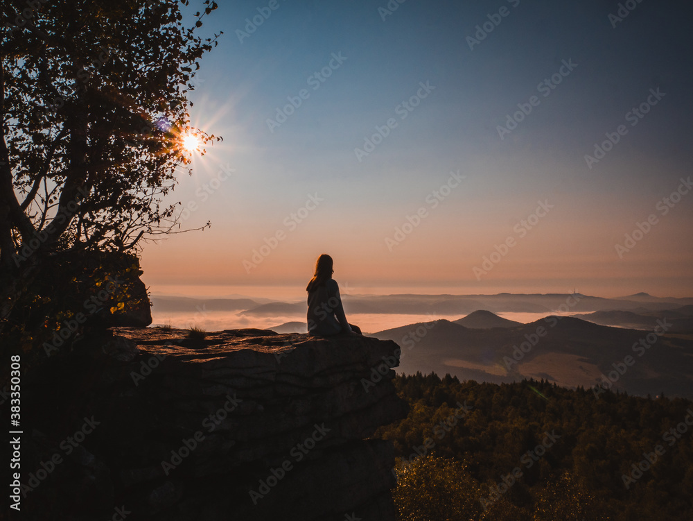 silhouette of a person sitting on a rock