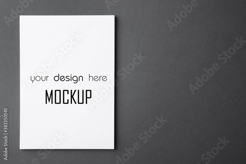 Paper sheet with text Mockup Your Design Here on dark grey background, top view