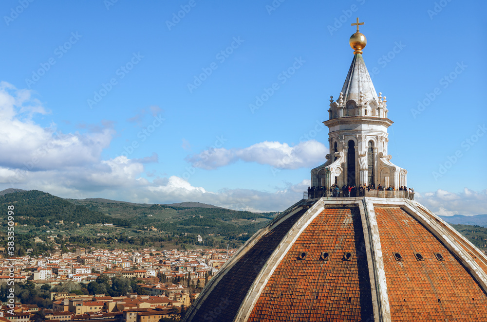 Detail of the dome of Florence cathedral of Santa Maria del Fiore (Saint Mary of the Flower), with the city, the hills of tuscany and the blue sky in background