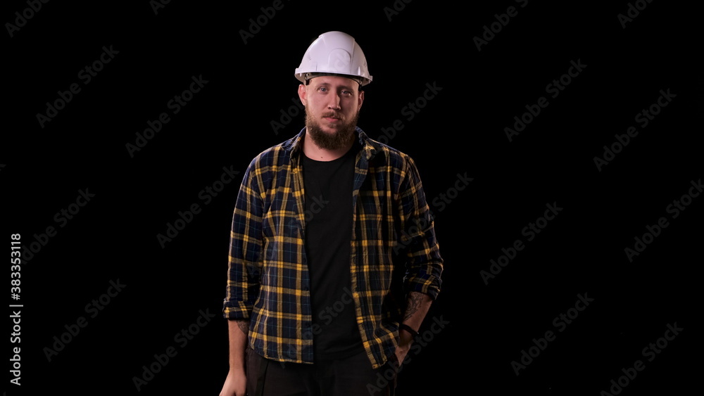 Foreman engineer puts on white helmet and looks at the camera. A real boss, man in plaid shirt, looks at his workers very seriously. Foreman engineer puts on white helmet and looks at the camera. A real boss, man in plaid shirt, looks at his workers very seriously.