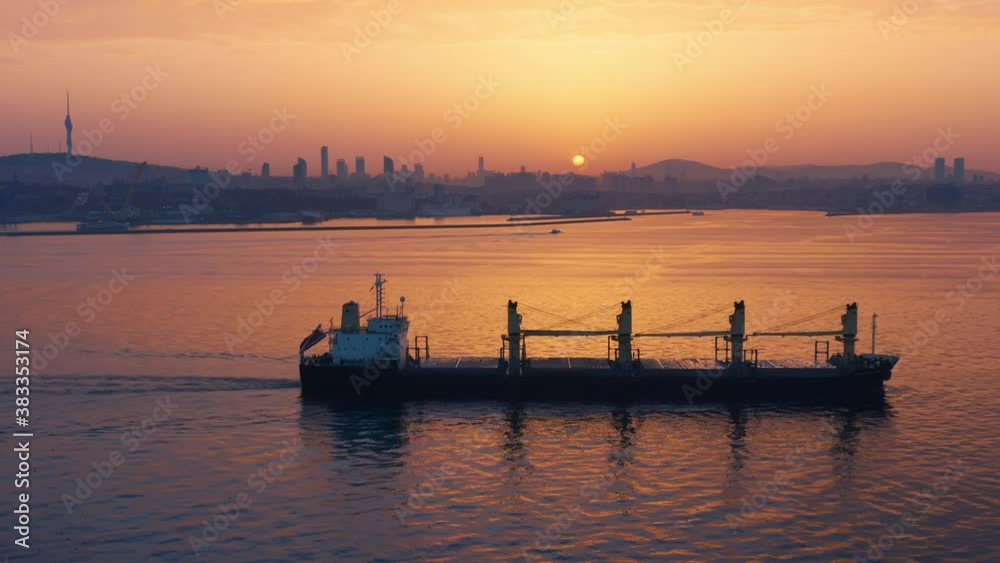 Cargo ship sails along the Bosphorus or Bosporus (also known as Strait of Istanbul) at sunset. Aerial view Cargo ship sails along the Bosphorus or Bosporus (also known as Strait of Istanbul) at sunset. Aerial view