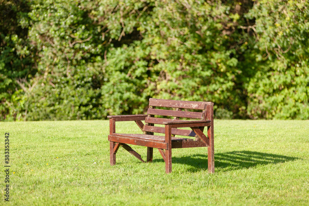 Wooden bench in a nature park in Northern Ireland. Nice day in summer, early autumn, natural background, outdoors.