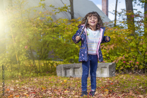 Happy young girl jumping in the forest in the foliage season