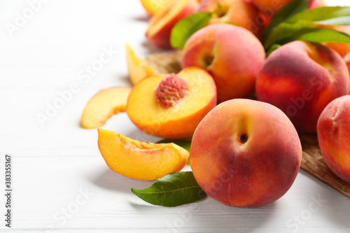 Fresh sweet peaches on white wooden table, closeup
