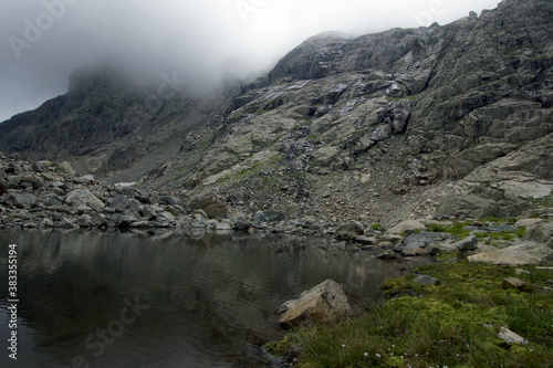 Alpine lake in a rocky valley. Valley in front of the Koshtan pass (3450 meters above sea level). Caucasus, Russia.