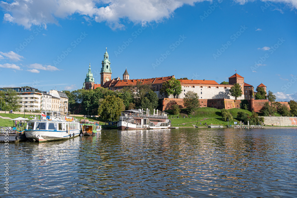 Barges in front of Wawel Castle on waterfront of Vistula river in Cracow, Poland