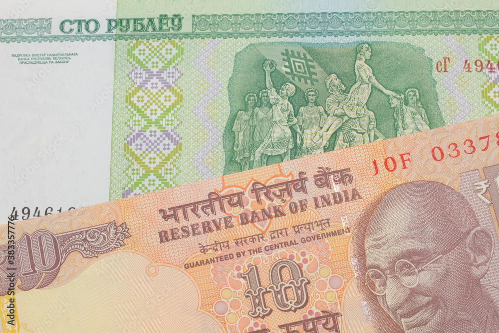 A macro image of a orange ten rupee bill from India paired up with a green one hundred ruble note from Belarus.  Shot close up in macro.