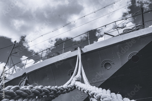 Nahaufnahme eines Haltetaus von einem großen Schiff am Hafen in Polen mit dem Blick nach oben richtung blauem Himmel. Dickes Ankerseil eines Kriegsschiff. in schwarzweiss monochrom. photo