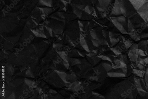 Blank crumpled and straightened black paper with wrinkles