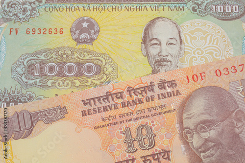 A macro image of a orange ten rupee bill from India paired up with a yellow one thousand dong bill from Vietnam.  Shot close up in macro.