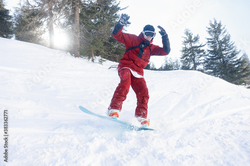 winter, leisure, sport and people concept - Active snowboarder jumping in mountains on a sunny day. Snowboarding closeup. Sheregesh ski resort