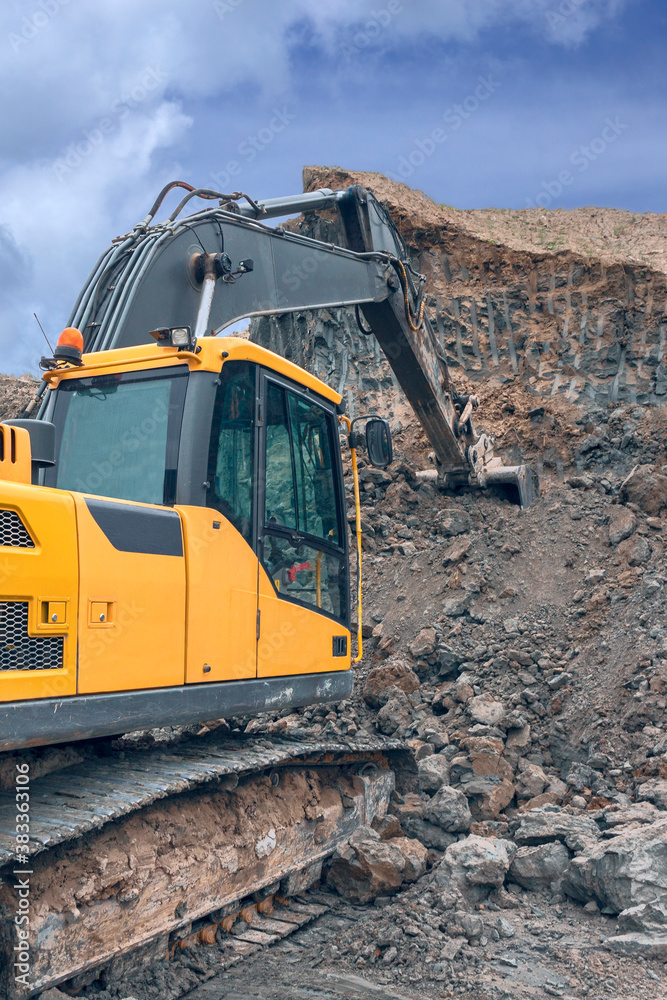 Obraz premium the process of loading soil with an excavator bucket into a truck at a construction site