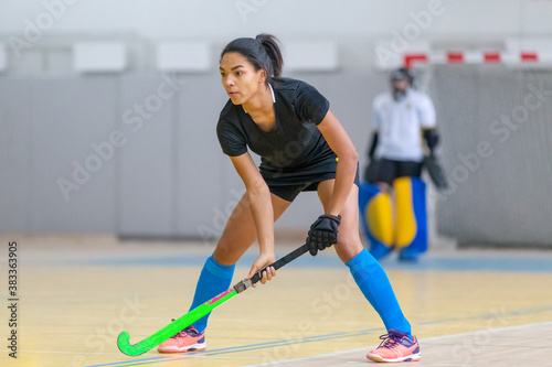 Young female hockey player in defence at the match