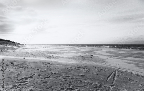 Fischerboote an der Küste der Osstsee am Strand in Polen in melancholischem schwarzweiss look. Strand an der Ostsee mit Fischerbooten und vielen Fußspuren im Sandstrand. Mondlandschaft Krater. photo