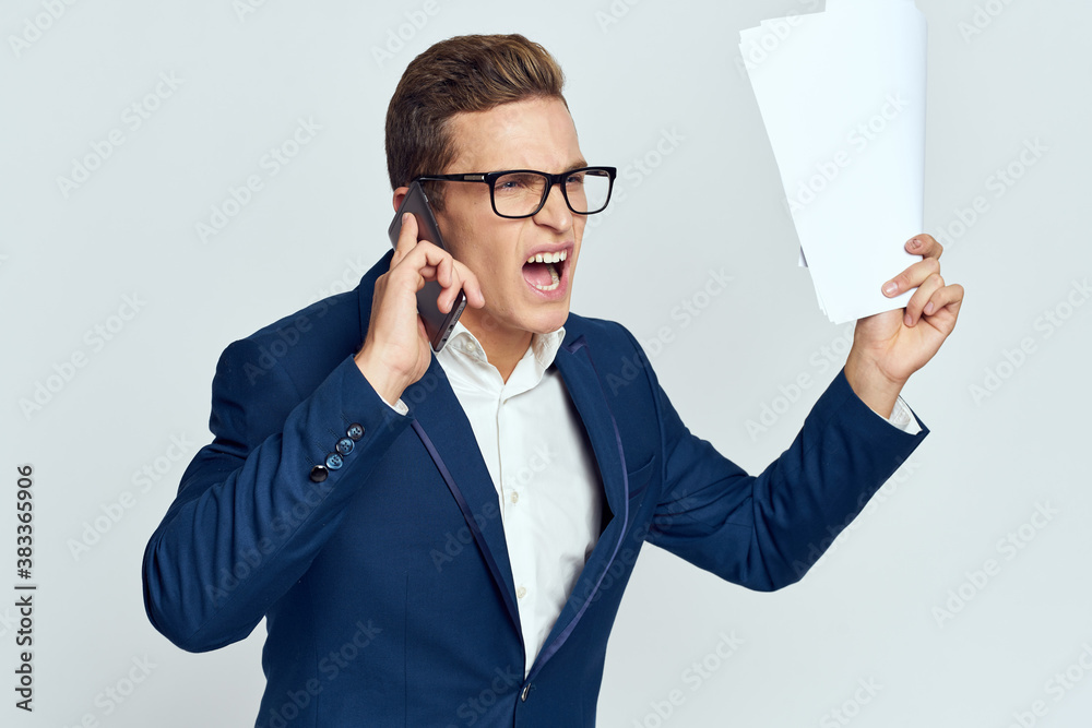 Business man in a suit talking on the phone with glasses with documents technology official Business man in a suit talking on the phone with glasses with documents technology official