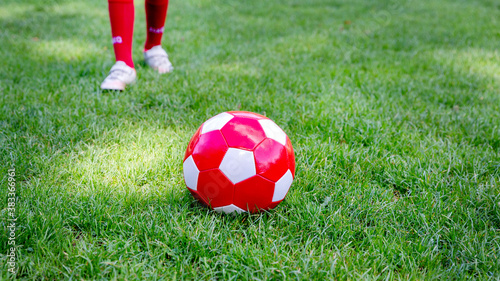 Red soccer ball on a green field