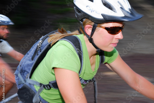 Close up of a female bike rider with male catching up