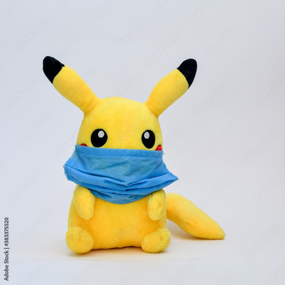 Pikachu toy wearing virus protective mask isolated on white background.  Stock Photo | Adobe Stock