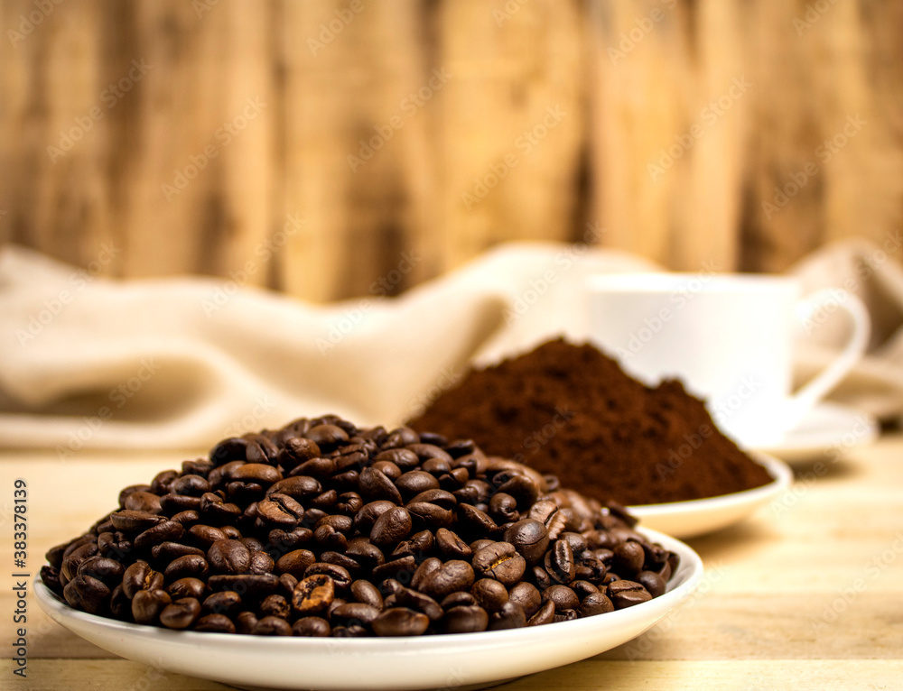 Roasted coffee grains on the background of cups with coffee Roasted coffee grains on the background of cups with coffee