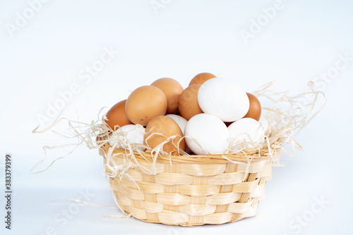 Close-up view of raw chicken eggs in egg box on white wooden background