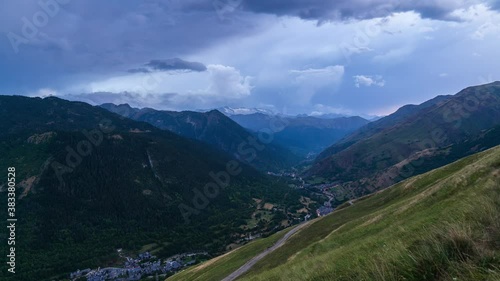 Beautiful valley with small typical mountain villages at background. Time Lapse video of panoramic view at sunset of Valle de Aran, Baqueira, Salardú, Lérida, Catalonia, Spain. photo